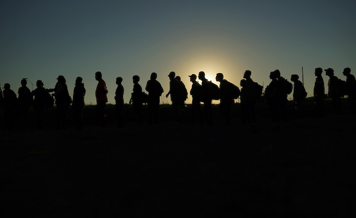 Migrantes que cruzaron el Río Bravo (o Grande) y entraron a Estados Unidos desde México formados para ser procesados por la Oficina de Aduanas y Protección Fronteriza, el 23 de septiembre de 2023, en Eagle Pass, Texas.