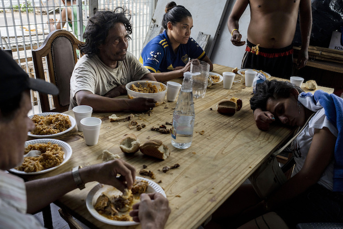 Personas almorzando en el comedor social de la Casa Comunitaria del Fondo en el barrio Padre Carlos Múgica de Buenos Aires, Argentina, el miércoles 13 de diciembre de 2023.