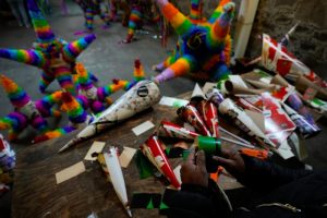 Un artesano de piñatas trabaja una con la forma tradicional, una esfera con siete picos, en un pequeño negocio familiar en Acolman, al norte de Ciudad de México, el miércoles 13 de diciembre de 2023. Esta artesanía tradicional tiene un origen religioso y está cargada de simbolismo: cada cono representa uno de los siete pecados capitales, por eso se golpea la piñata hasta destruirla como una forma de alejarse de esos pecados.