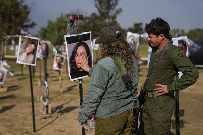 Soldados israelíes miran fotos de personas muertas o en cautiverio de Hamás durante el ataque de los milicianos al festival musical Nova en el sur de Israel, exhibidas en el lugar del hecho para conmemorar la masacre del 7 de octubre, cerca del kibbutz Re'im, viernes 1 de diciembre de 2023.