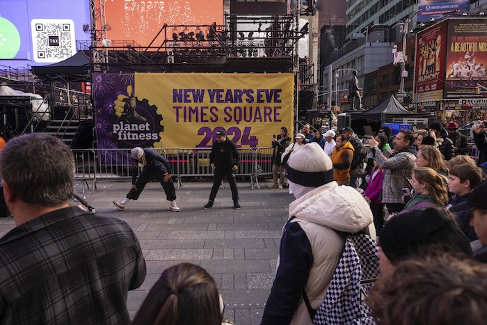 Turistas pasan junto a un cartel de Fin de Año antes de la celebración en Times Square, Nueva York, el 29 de diciembre de 2023.