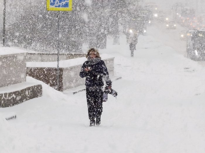 Un hombre camina por una calle en medio de una fuerte nevada en Moscú, Rusia, el lunes 4 de diciembre de 2023.