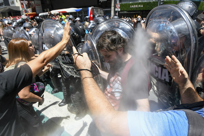 Un oficial de policía usa spray de pimienta contra manifestantes antigubernamentales que protestan contra las reformas económicas del Presidente argentino Javier Milei frente a la Corte Suprema mientras los sindicatos impugnan legalmente las medidas en Buenos Aires, Argentina, el miércoles 27 de diciembre de 2023.