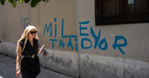 Una mujer pasa junto a una pinta contra el Presidente Javier Milei, el jueves 21 de diciembre de 2023, en Buenos Aires, Argentina.