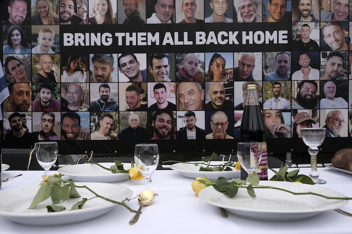 Fotografías de los rehenes secuestrados durante el ataque de Hamás a Israel del 7 de octubre de 2023 se encuentran frente a una mesa colocada durante una protesta ante la Corte Internacional de Justicia, el viernes 12 de enero de 2024, en La Haya, Holanda.