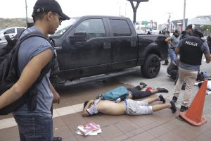 Hombres yacen boca abajo en el suelo detenidos por policías afuera de TC Televisión, luego de que un productor le dijera a la policía que formaban parte de un grupo que irrumpió en su set durante una transmisión en vivo, en Guayaquil, Ecuador, el martes de 9 de enero de 2024.