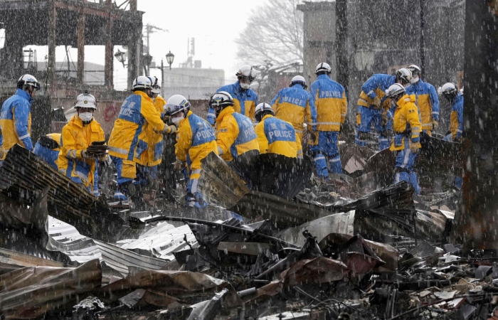 Cae la lluvia mientras agentes de policía retiran escombros tras un incendio en un mercado en Wajima, prefectura de Ishikawa, Japón, el sábado 6 de enero de 2024. Foto: Kyodo News vía AP