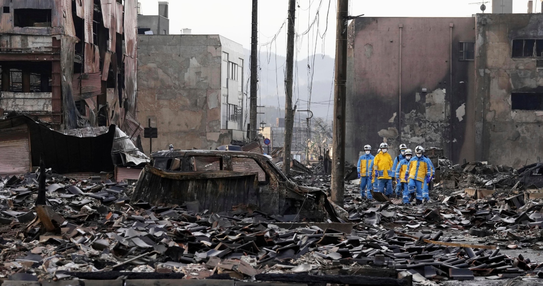 Agentes de policía durante un operativo de búsqueda en las inmediaciones de un mercado calcinado, en Wajima, en la prefectura de Ishikawa, Japón, el 6 de enero de 2024. Foto: Kyodo News vía AP