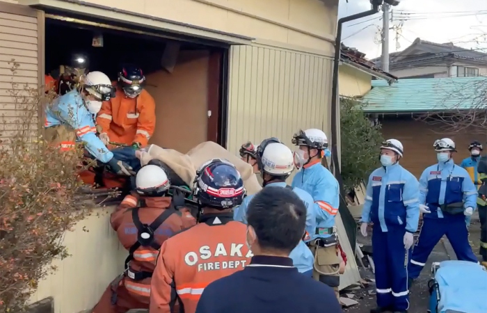 En esta imagen una mujer es sacada en camilla tras ser encontrada bajo su casa destruida 72 horas después de un potente sismo en Wajima, en la prefectura de Ishikawa, Japón, el 4 de enero de 2024. Foto: Departamento de Bomberos de Osaka vía AP