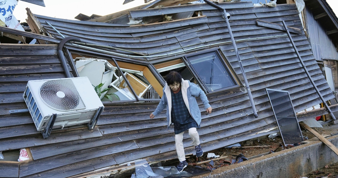 Una mujer camina entre las ruinas de su casa el viernes 5 de enero de 2024, en Wajima, prefectura de Ishikawa, Japón. Foto: Kyodo News, vía AP