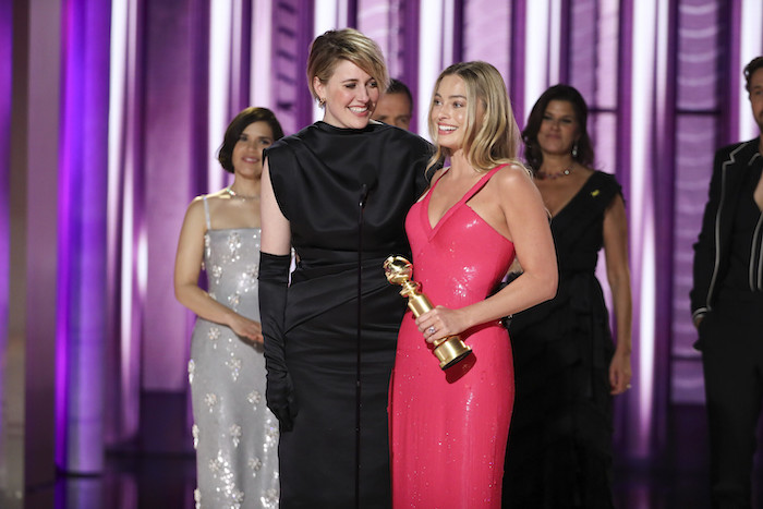 En esta imagen proporcionada por CBS, la directora Greta Gerwig, izquierda, y la actriz Margot Robbie reciben el premio al Logro Cinematográfico y de Taquilla por “Barbie” en la 81a edición de los Globos de Oro el domingo 7 de enero de 2024, en el Hotel Beverly Hilton en Beverly Hills, California.