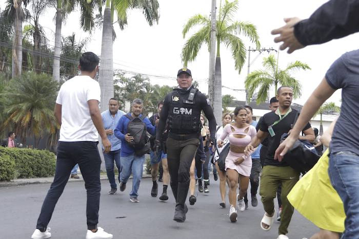 La policía evacúa a personal del canal TC Televisión después de que un grupo armado y encapuchado irrumpiera en plena transmisión en directo, en Guayaquil, Ecuador, el martes 9 de enero de 2024.