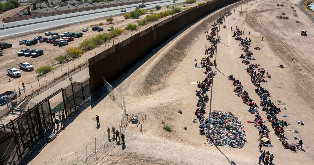 Migrantes forman filas frente a la valla en la frontera de Estados Unidos con México a la espera de ser transportados a una instalación de la Patrulla Fronteriza, el 10 de mayo de 2023, en El Paso, Texas.