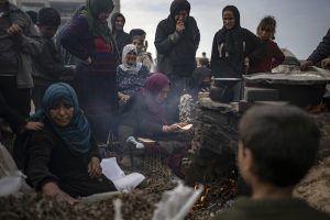 Palestinos desplazados por los bombardeos israelíes esperan su turno para cocer pan en el campamento improvisado en Muwasi, en Rafah, en el sur de Gaza, el 23 de diciembre de 2023.