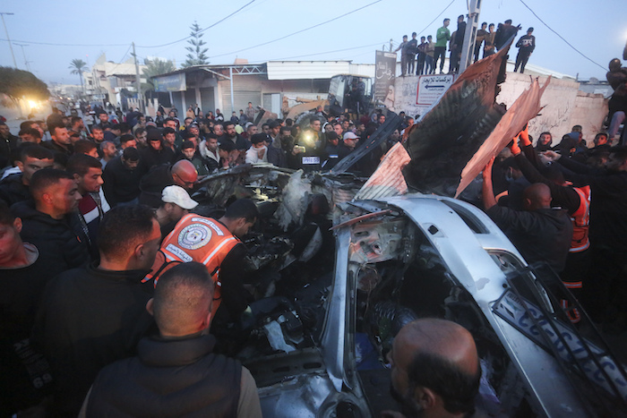 Palestinos rodean un auto alcanzado por un ataque aéreo israelí en Rafah, en la Franja de Gaza, el sábado 20 de enero de 2024.