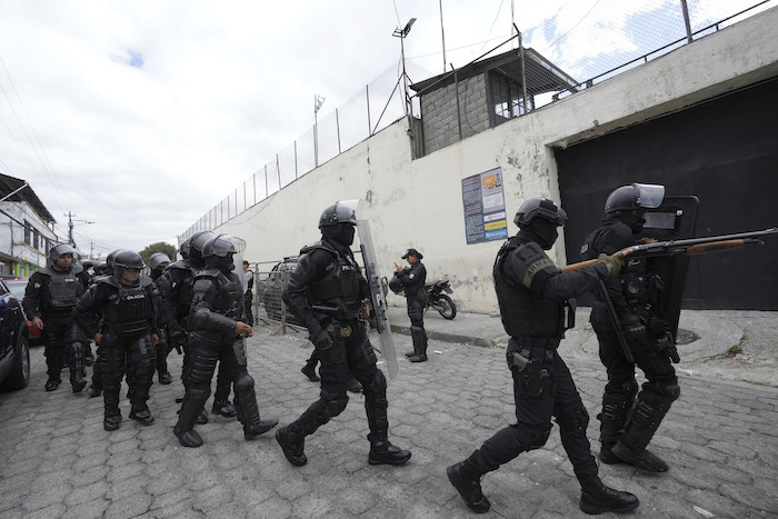 Policías y soldados se preparan para ingresar a la prisión El Inca, donde se registran disturbios, en Quito, Ecuador, el lunes 8 de enero de 2024.