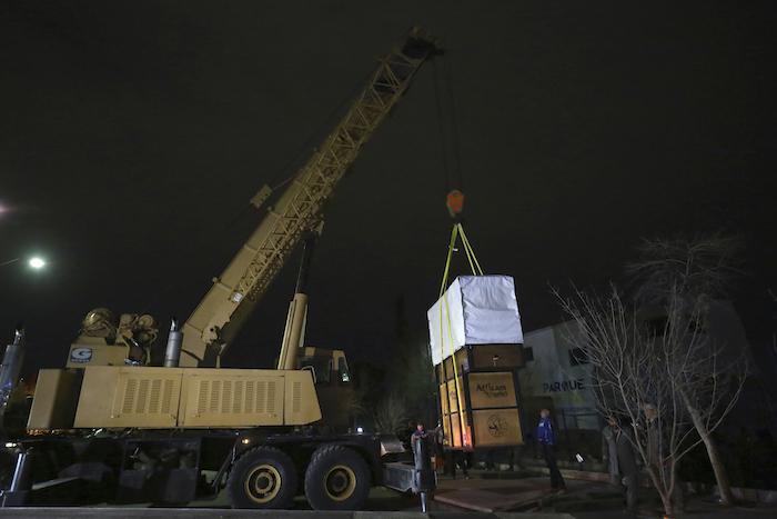 Trabajadores cargan en un tráiler el contenedor en el que se trasladará la jirafa Benito desde desde el zoológico estatal Parque Central de Ciudad Juárez, México, el domingo 21 de enero de 2024.