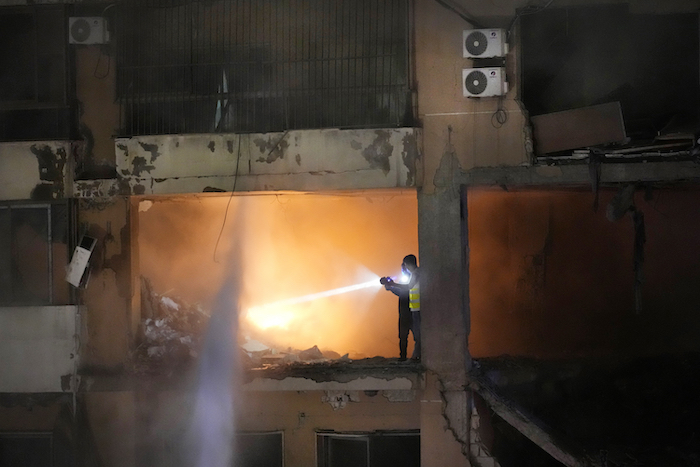 Trabajadores de defensa civil buscan a sobrevivientes dentro de un apartamento tras una explosión masiva, el martes 2 de enero de 2024, en un suburbio sureño de Beirut, Líbano.