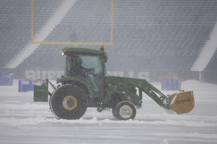 Trabajadores retiran la nieve del Estadio Highmark de Orchard Park, Nueva York., el domingo 14 de enero de 2024.