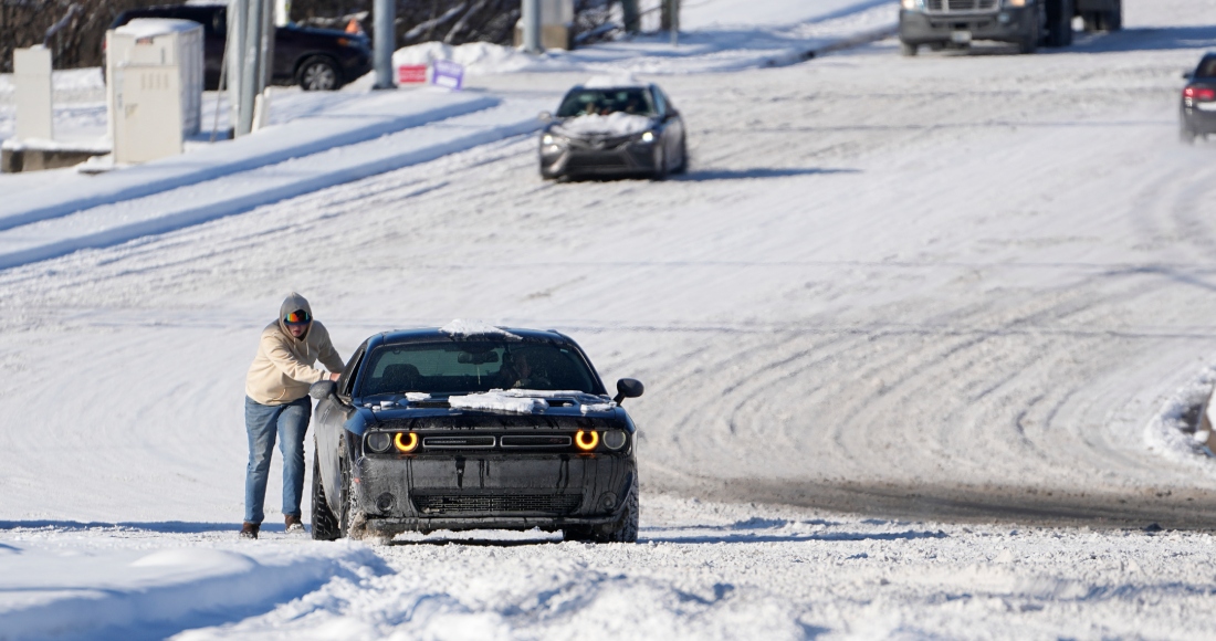 Un automovilista empuja su vehículo en un camino nevado el martes 16 de enero de 2024, en Nashville, Tennessee.