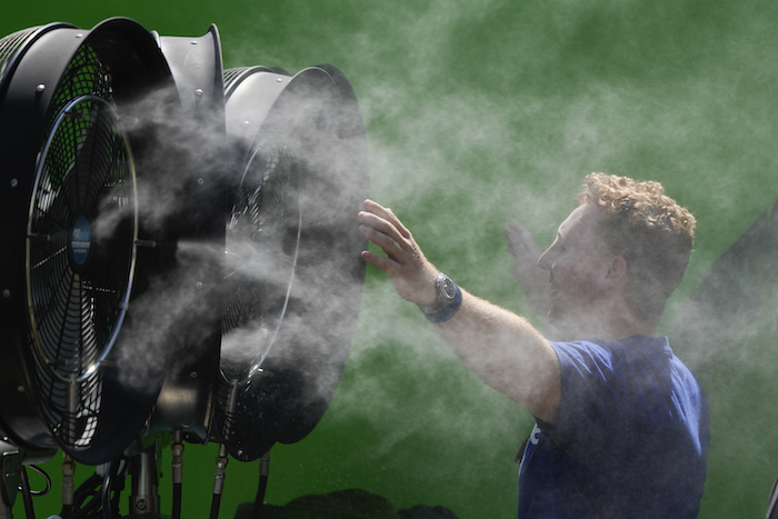 Un espectador se refresca durante una jornada de entrenamiento previa al Abierto de Australia en Melbourne Park, Melbourne, Australia, 12 de enero de 2024.