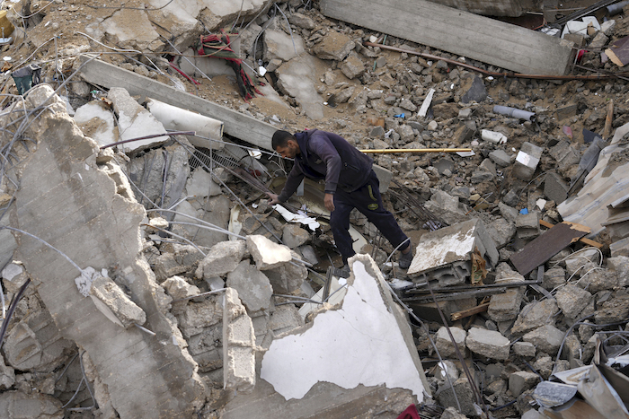 Un hombre avanza entre escombros tras un ataque israelí, el domingo 14 de enero de 2024, en Deir al Balah, Franja de Gaza.