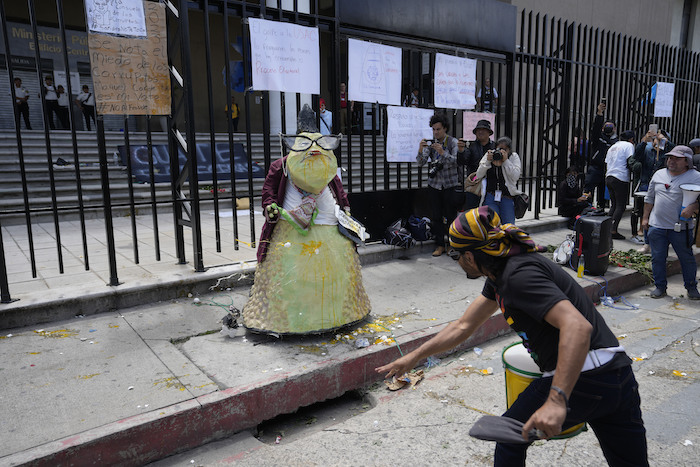 Un manifestante arroja huevos a una figura que representa a la Fiscal General, Consuelo Porras, en una protesta a las afueras de la institución en Ciudad de Guatemala, el 13 de julio de 2023.