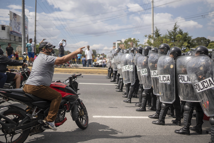 En esta imagen de archivo, un manifestante confronta a la policía durante una huelga general, en la Ciudad de Guatemala, el 10 de octubre de 2023. La población salió a la calle para protestar en favor del Presidente electo, Bernardo Arévalo, luego de que el máximo tribunal del país ratificó la decisión de la Fiscalía de suspender su partido político por supuesto fraude en el registro de votantes.