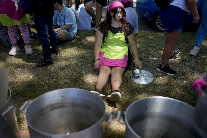 Un manifestante se sienta afuera de la residencia presidencial de Olivos junto a ollas vacías para protestar contra las reformas económicas del Gobierno en Buenos Aires, Argentina, el martes 23 de enero de 2024.