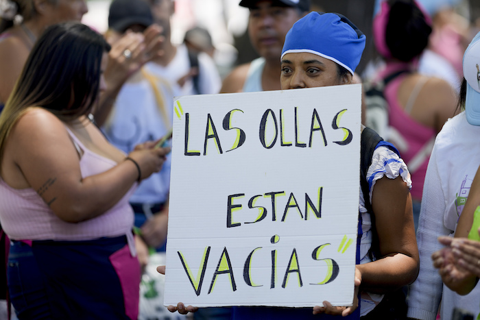 Un manifestante sostiene un cartel que dice "Las ollas están vacías" durante una manifestación contra las reformas económicas del Gobierno frente a la residencia presidencial de Olivos en Buenos Aires, Argentina, el martes 23 de enero de 2024.