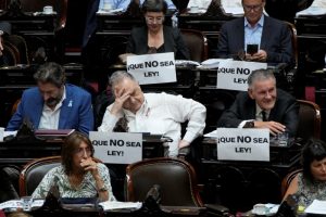 Legisladores en el debate de la reforma económica del presidente argentino Javier Milei en la Cámara de Diputados con carteles de rechazo para que no sea aprobada, en Buenos Aires, Argentina, el viernes 2 de febrero de 2024. 