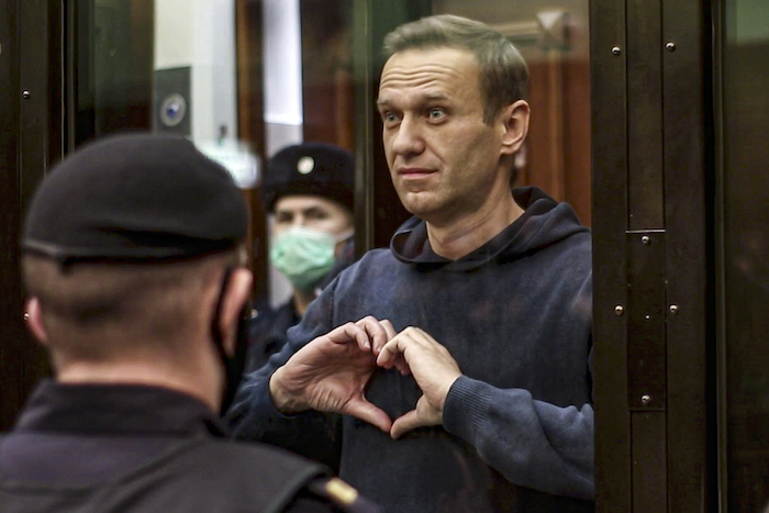 En esta imagen de archivo, tomada de un video distribuido por la Corte de la Ciudad de Moscú, el 2 de febrero de 2021, el líder opositor ruso Alexei Navalny hace un corazón con sus manos desde el espacio reservado para los acusados durante una vista en el tribunal, en Moscú, Rusia.