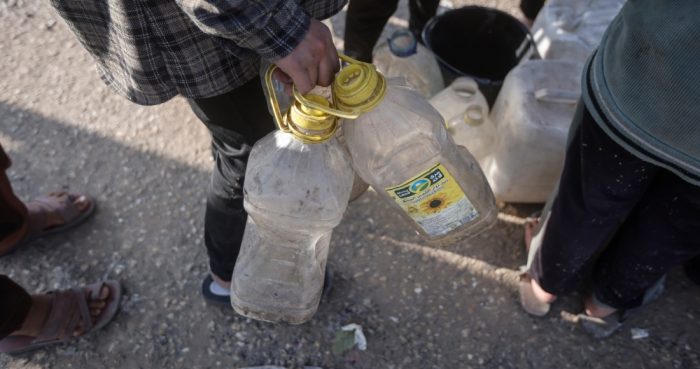 Palestinos desplazados por la ofensiva terrestre israelí en la Franja hacen fila para obtener agua, en un campamento improvisado en Rafah, Gaza, el 19 de febrero de 2024.