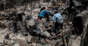 Residentes se abrazan entre los restos de casas calcinadas luego que incendios forestales alcanzaron su vecindario, el domingo 4 de febrero de 2024, en Viña del Mar, Chile.