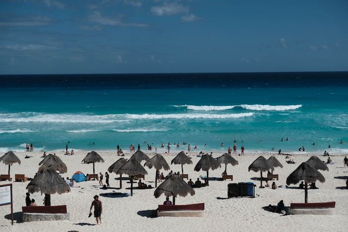 Turistas disfrutan de Playa Delfines en Quintana Roo.