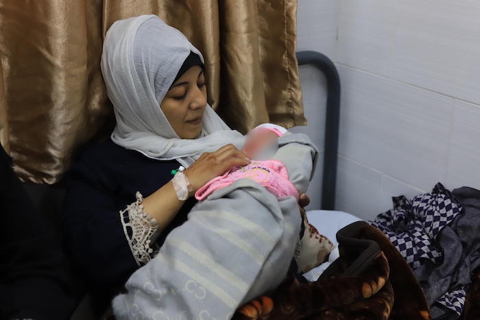 Mona Dernouna sostiene a su recién nacido en la sala materna del hospital emiratí de Rafá. Gaza, 15 de enero de 2024.