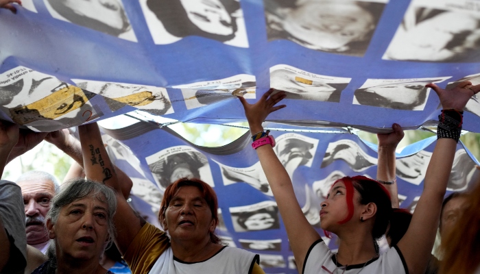 Los manifestantes portan una pancarta con fotografías de personas desaparecidas durante la dictadura militar de 1976-1983 durante una marcha que conmemora el 48 aniversario del golpe de Estado en Buenos Aires, Argentina, el domingo 24 de marzo de 2024.