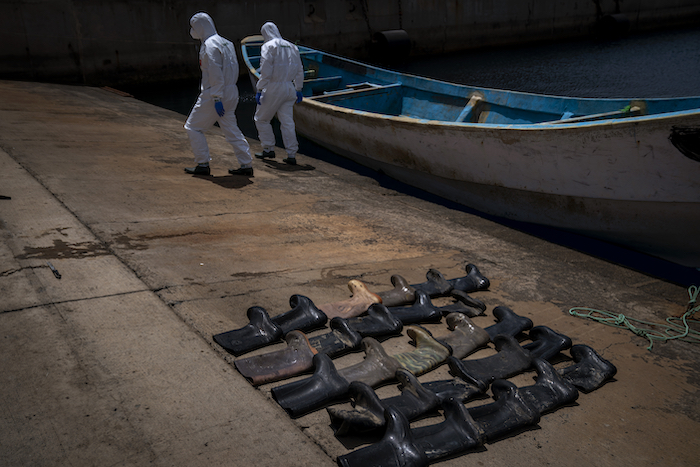 Botas de agua colocadas en el suelo por agentes de policía mientras revisan un bote encontrado a la deriva en el Atlántico con los cadáveres de 15 malienses, el jueves 20 de agosto de 2020, en la isla de Gran Canaria, España.