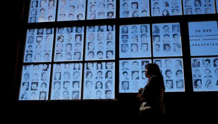 Claudia Poblete posa frente a una exhibición de fotografías de personas desaparecidas durante la dictadura militar de Argentina en el Museo del Espacio para la Memoria y la Promoción y Defensa de los Derechos Humanos, en Buenos Aires, Argentina, el viernes 22 de marzo de 2024. Poblete es una de los 133 "nietas recuperadas" de Argentina. 