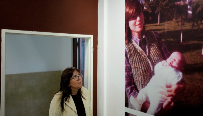 Claudia Poblete posa para una fotografía junto a una imagen de ella misma cuando era niña y su madre desaparecida Marta Gertrudis, en el Museo Espacio para la Memoria y la Promoción y Defensa de los Derechos Humanos, en Buenos Aires, Argentina, el viernes 22 de marzo de 2024.