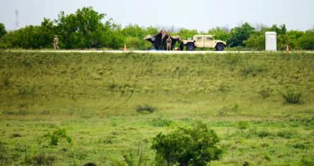 Dos miembros de la Guardia Nacional patrullan un área de tierra detrás del muro fronterizo federal la tarde del martes 19 de marzo de 2024, en Mission, Texas.