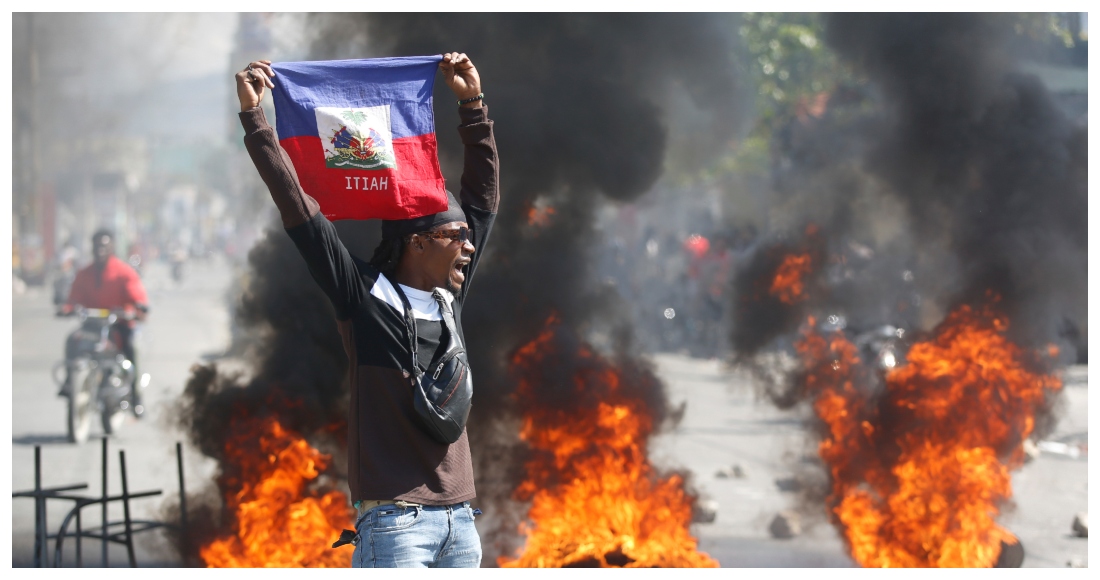 Un manifestante muestra una bandera haitiana durante una protesta para exigir la renuncia del Primer Ministro del país, Ariel Henry, en Puerto Príncipe, Haití, el 1 de marzo de 2024.