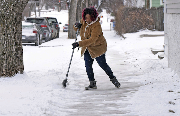 Josephine Wiea quita nieve de una acera el jueves 21 de marzo de 2024, en Bismarck, Dakota del Norte.