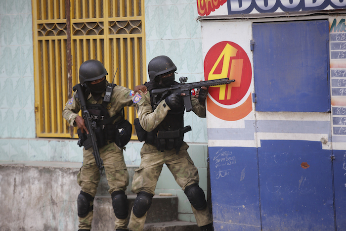 Policías se resguardan durante un operativo antipandillas en el vecindario Portail el jueves 29 de febrero de 2024, en Puerto Príncipe, Haití.