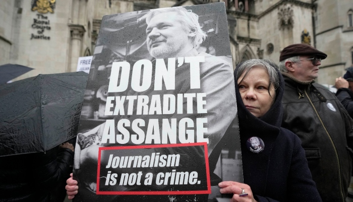 Una manifestante sostiene una pancarta frente a los Tribunales Reales de Justicia en Londres, el 21 de febrero de 2024, en apoyo al fundador de WikiLeaks, Julian Assange.