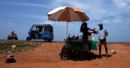 Un hombre compra una bebida refrescante de un vendedor ambulante en un día soleado, el 29 de febrero de 2024, en Mahawewa, un poblado ubicado al norte de Colombo, Sri Lanka.