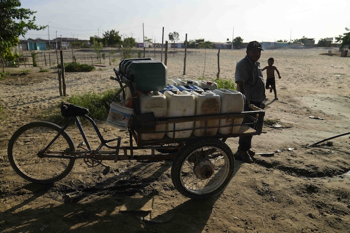 Un hombre espera su turno para rellenar de agua varios recipientes en Piura, Perú, el jueves 29 de febrero de 2024.