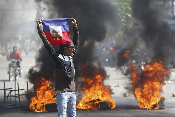 Un manifestante muestra una bandera haitiana durante una protesta para exigir la renuncia del primer ministro del país, Ariel Henry, en Puerto Príncipe, Haití, el 1 de marzo de 2024.