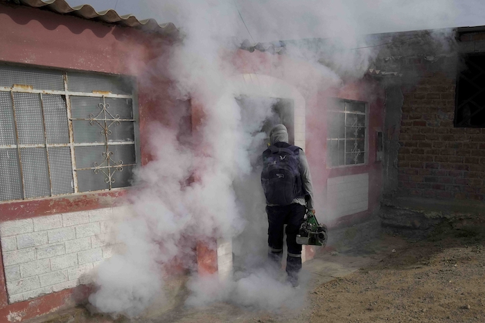 Un trabajador de salud sale de una casa tras fumigar contra mosquitos para ayudar a mitigar la expansión de los casos de dengue en el barrio de Las Peñitas de Talara, Perú, el viernes 1 de marzo de 2024.