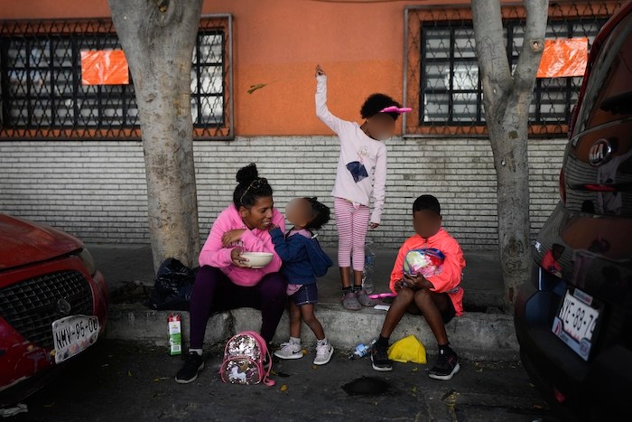 Una familia de migrantes venezolanos desayuna junto a las vías del tren bordeadas por tiendas de campaña improvisadas en la Ciudad de México, el martes 26 de marzo de 2024.